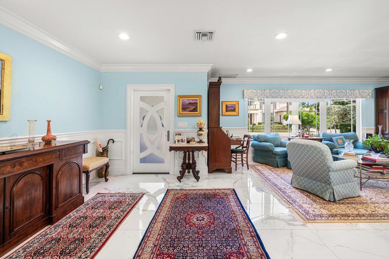 A bright foyer with white marble floors, light blue walls, and a patterned area rug — 2177 Areca Palm Road, Boca Raton FL 33432, BOCA RATON, FL
