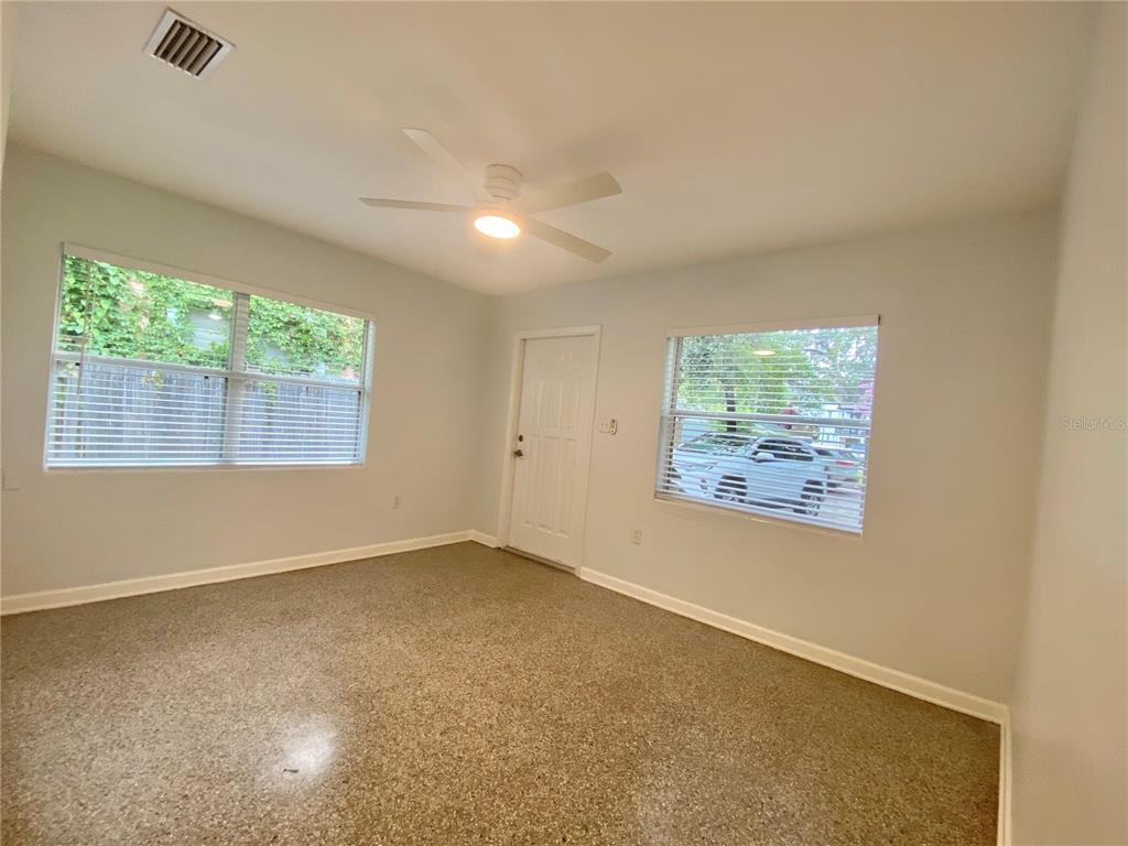 A living room features a glass coffee table, a gray media console, and a circular rug — 1022 DELANEY PARK DRIVE UNIT 1020, ORLANDO, FL