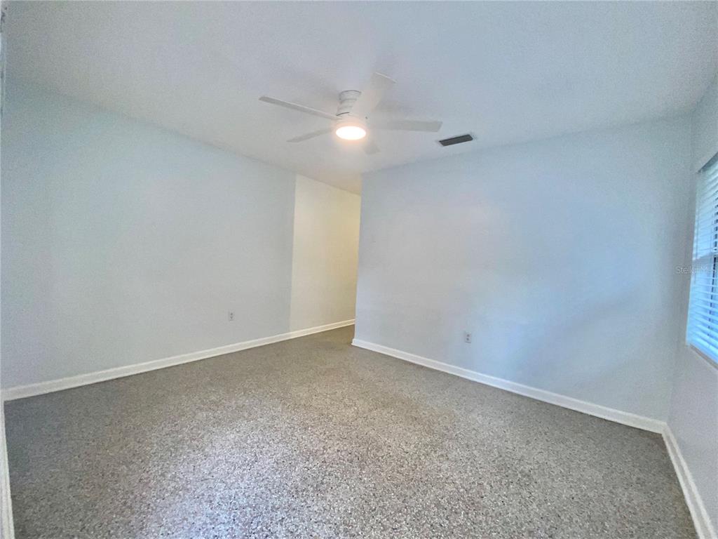An empty room with light gray walls, a ceiling fan, and speckled flooring — 1022 DELANEY PARK DRIVE UNIT 1020, ORLANDO, FL