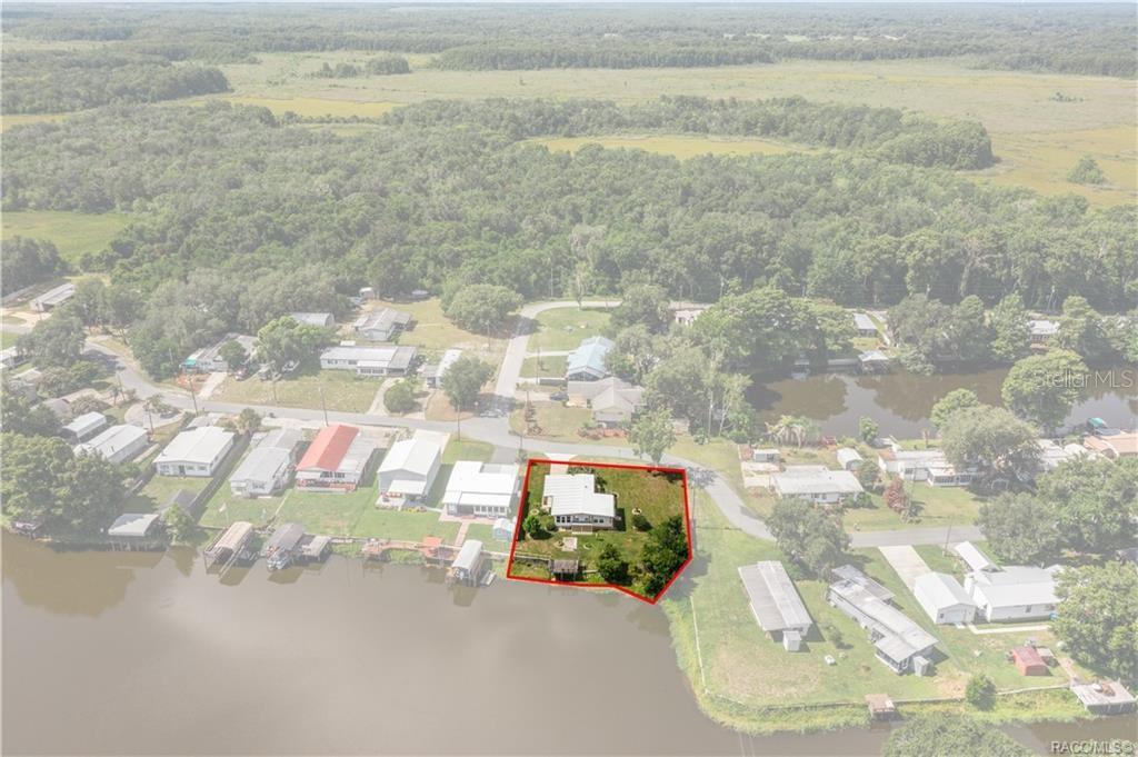 An aerial view shows a waterfront house with a large yard outlined in red — 10312 E PIKE DRIVE, INVERNESS, FL