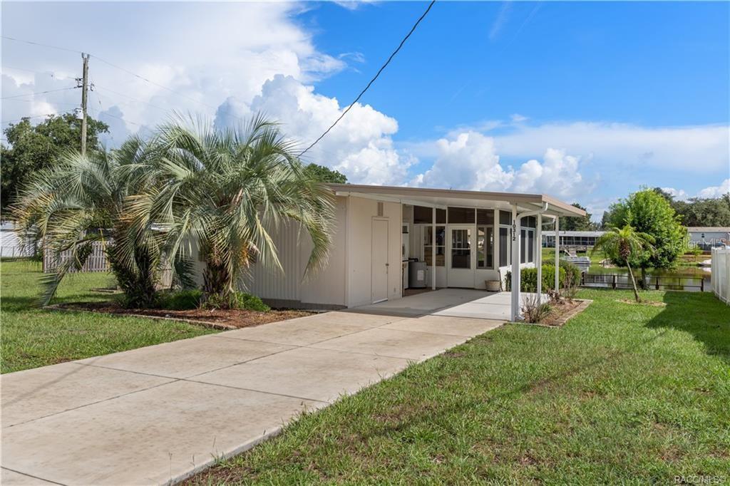 A single-story house with a concrete driveway, a screened-in porch, and palm trees — 10312 E PIKE DRIVE, INVERNESS, FL
