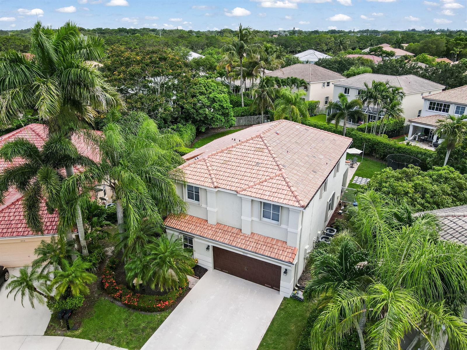 An aerial view shows a two-story house with a tile roof, garage, and surrounding landscaping — 4411 Stone Ridge Way, Weston FL 33331, WESTON, FL