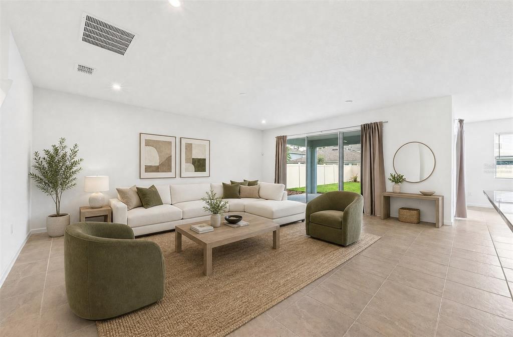 A living room features a white sectional sofa, two green armchairs, and tile flooring — 891 HONEY PETAL LANE, DELAND, FL
