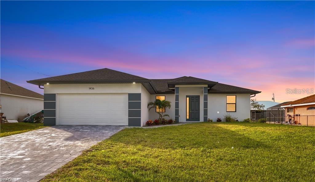 A single-story house with a white stucco exterior, a two-car garage, and a paved driveway — 1436 NW 31ST AVENUE, CAPE CORAL, FL