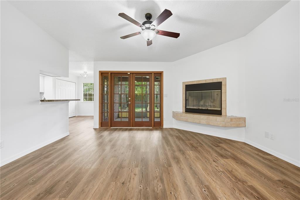 A bright living room features a fireplace, a wood coffee table, and a ceiling fan — 1356 6TH STREET, ORANGE CITY, FL