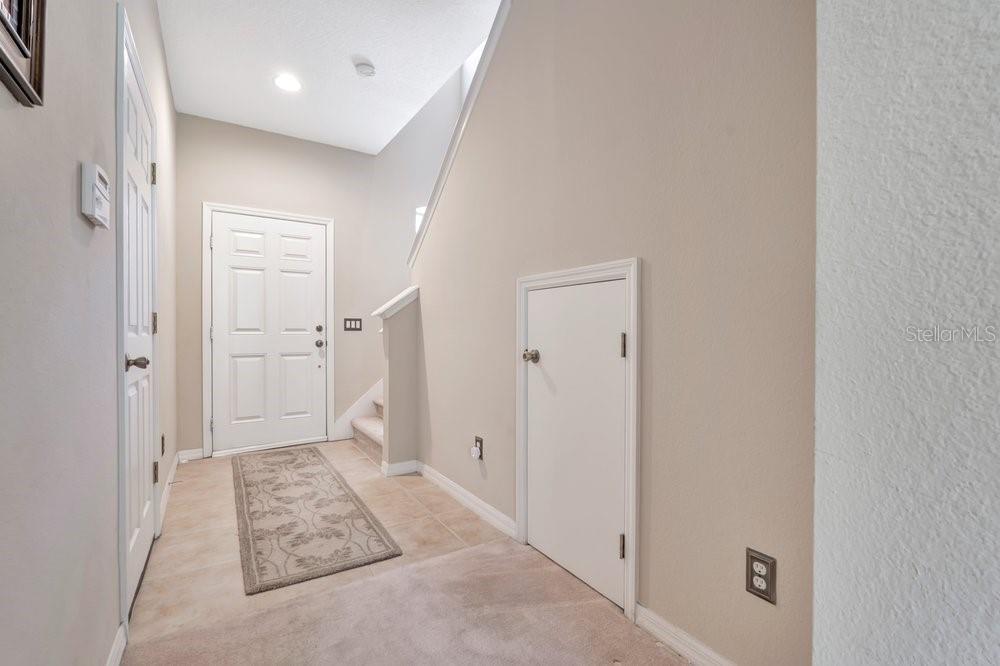 An entryway features tile flooring, a white front door, and a small under-stair storage door — 617 PINEBRANCH CIRCLE, WINTER SPRINGS, FL
