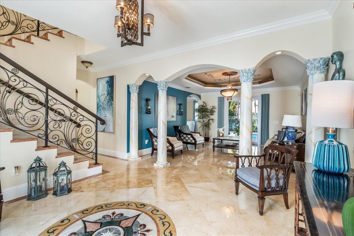 A grand foyer features marble floors, a wrought-iron staircase, and decorative columns leading to a living area — 7851 NW 166th Ter, Miami Lakes FL 33016, MIAMI LAKES, FL