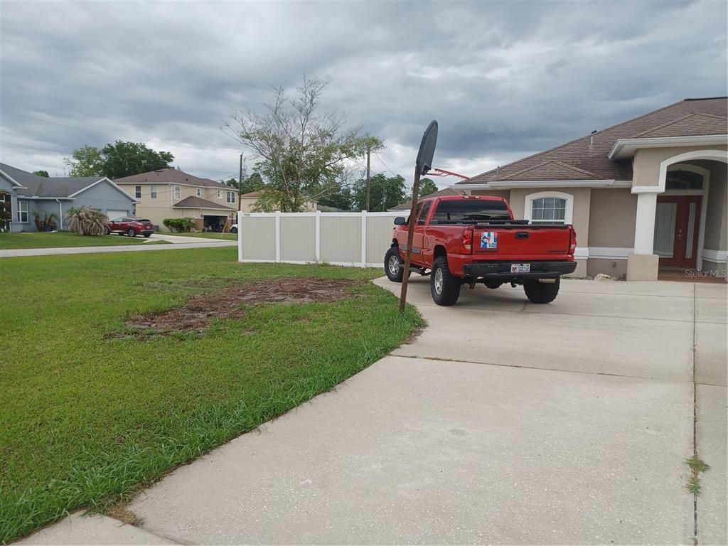 A red pickup truck is parked in the driveway of a suburban house — 10 ROCKEFELLER DRIVE, PALM COAST, FL