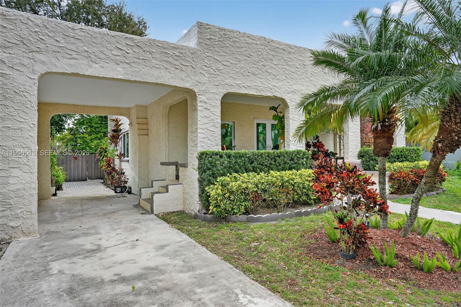 A single-story house with a textured stucco exterior, a carport, and a landscaped front yard — 1649 SW 11th Ter, Miami FL 33135, MIAMI, FL