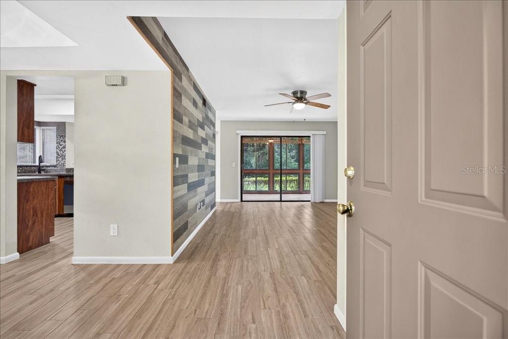 An interior view shows a living area with wood-look flooring and a decorative accent wall — 15 SHERBURY COURT, PALM COAST, FL