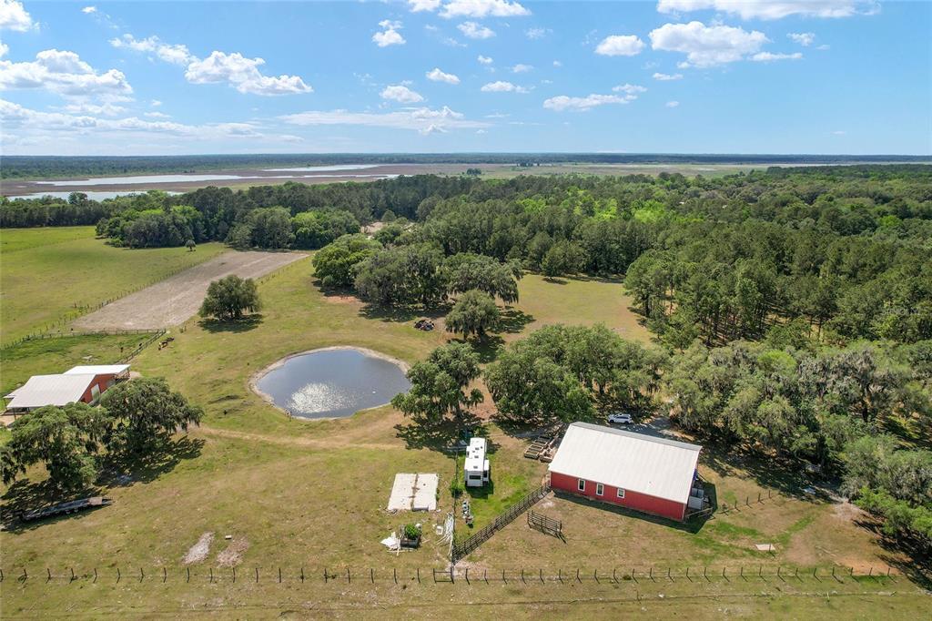 An aerial view shows a red barn, a small pond, and a trailer on rural land — 15120 SE 85TH STREET, OCKLAWAHA, FL