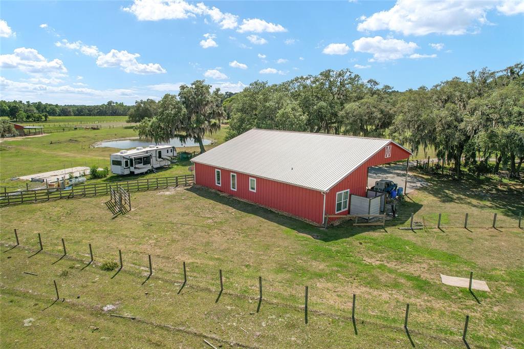 An aerial view shows a red barn with a metal roof on a grassy lot — 15120 SE 85TH STREET, OCKLAWAHA, FL