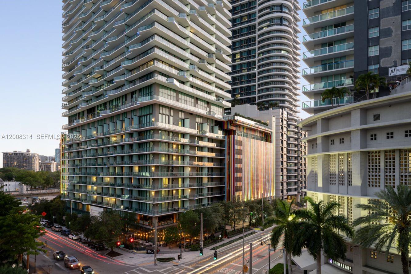 An exterior view of modern high-rise apartment buildings with balconies and a colorful parking garage — 1300 S Miami Ave # 2907, Miami FL 33130, MIAMI, FL