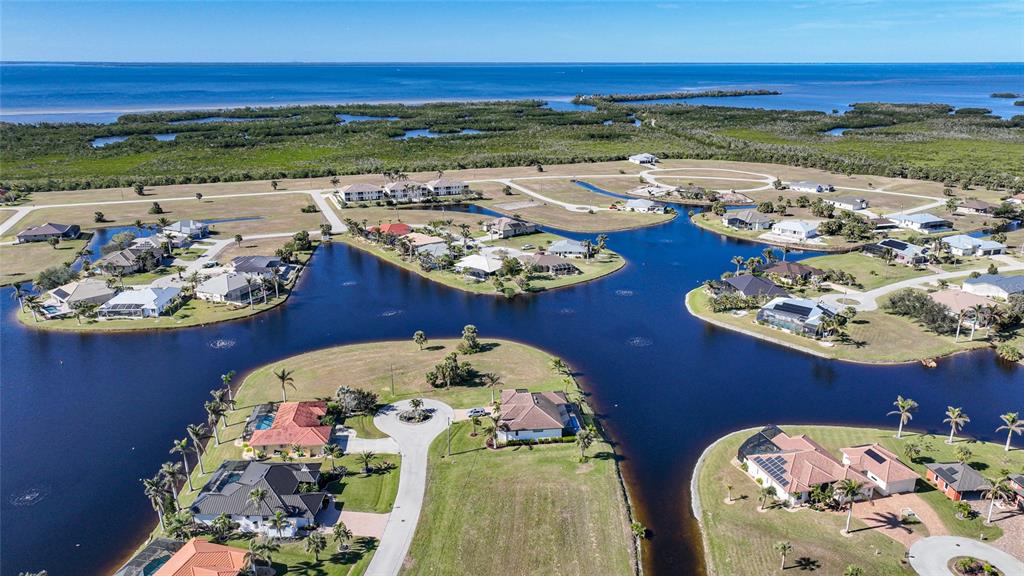 An aerial view shows waterfront houses situated on peninsulas surrounded by a large lake — 17146 ANTHEM LANE, PUNTA GORDA, FL