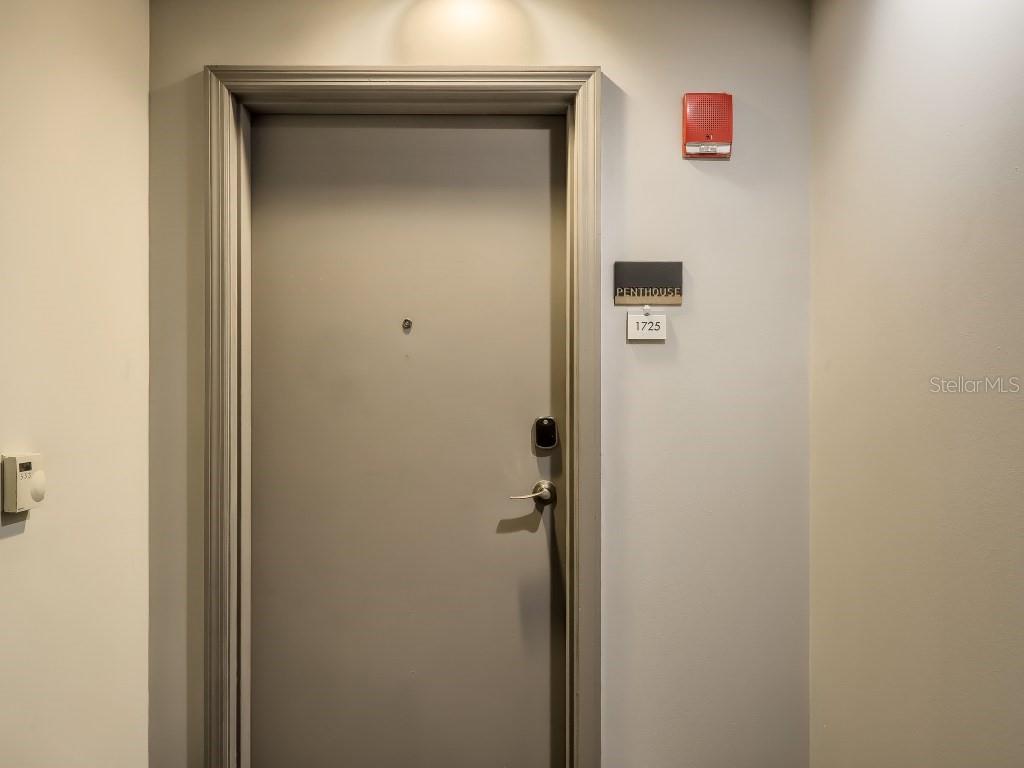 A gray door with a peephole, electronic lock, and a penthouse unit sign — 415 E PINE STREET UNIT PH, ORLANDO, FL