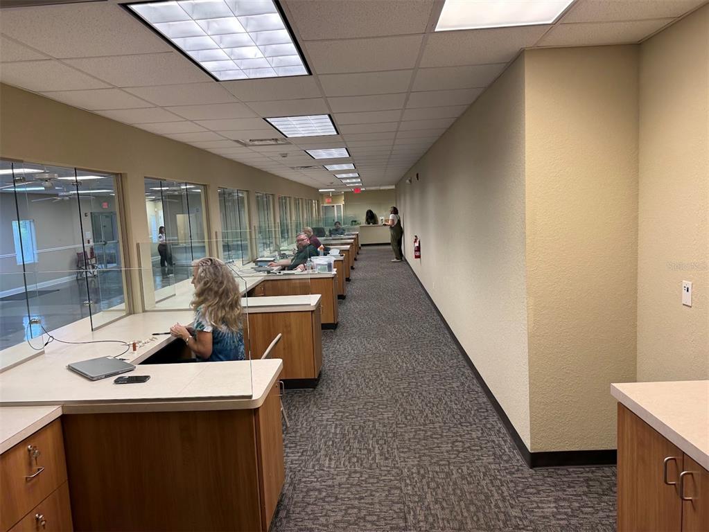 A large office space features a long service counter with glass partitions and tiled flooring — 5431 E SILVER SPRINGS BOULEVARD UNIT C, SILVER SPRINGS, FL