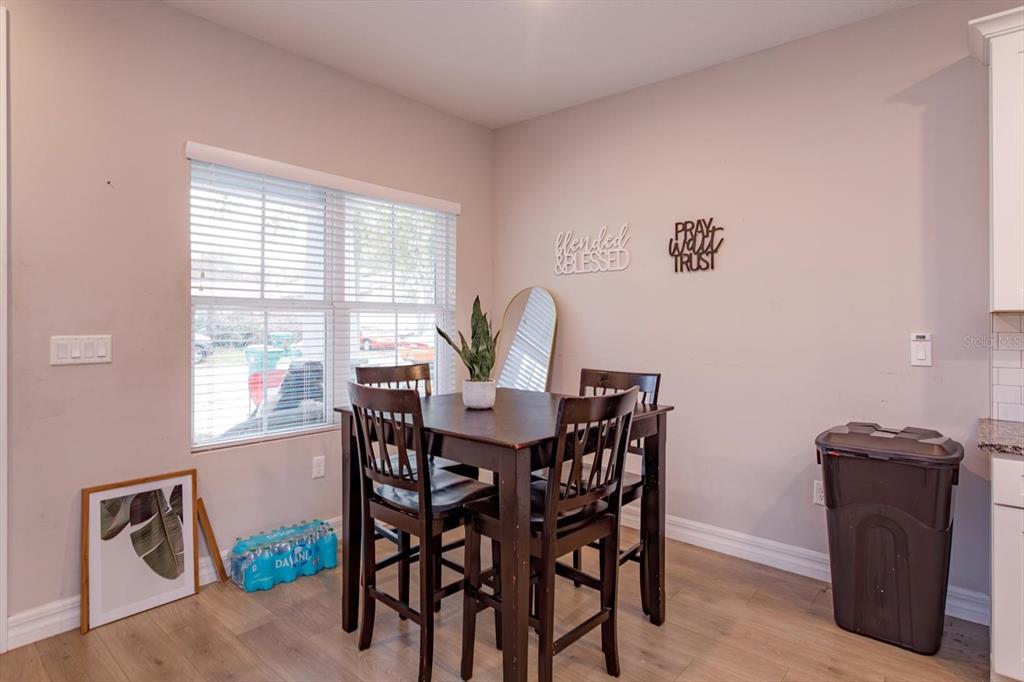 A dining area features a dark wood table with four chairs and wall-mounted decor — 884 KLONDIKE STREET, WINTER GARDEN, FL