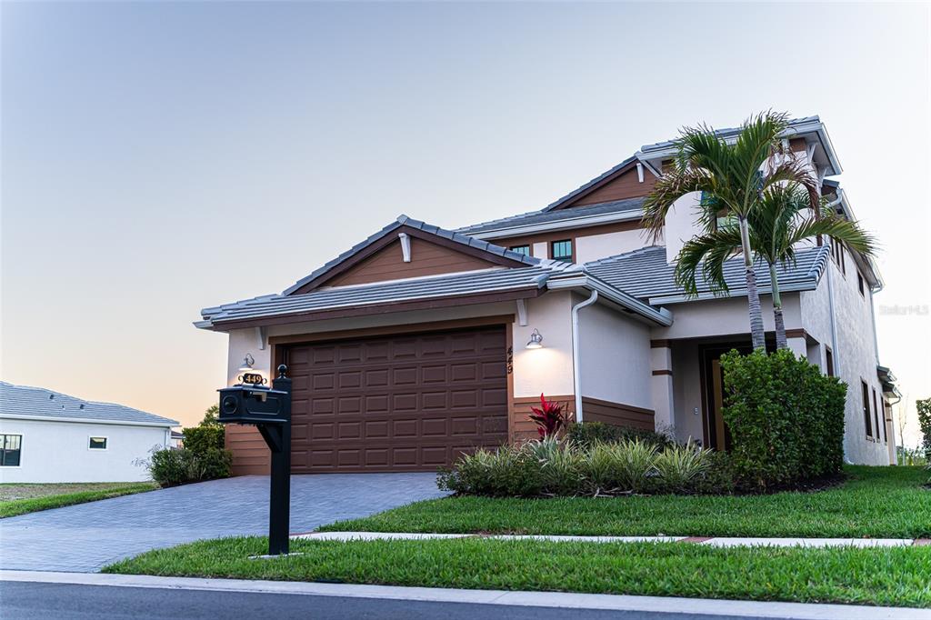 A two-story house with a brown garage door, a paved driveway, and a front lawn — 449 SE FASCINO CIRCLE, PORT ST LUCIE, FL