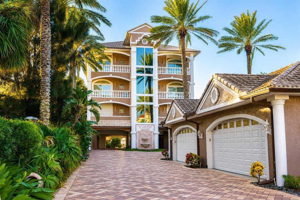 A multi-story residential building with balconies and a paved driveway leading to attached garages — 3800 GULF BOULEVARD UNIT PH, ST PETERSBURG, FL