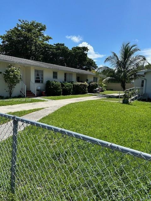 A single-story apartment building with a chain-link fence in the foreground and a palm tree — 474 NW 26th Ave, Miami FL 33125, MIAMI, FL