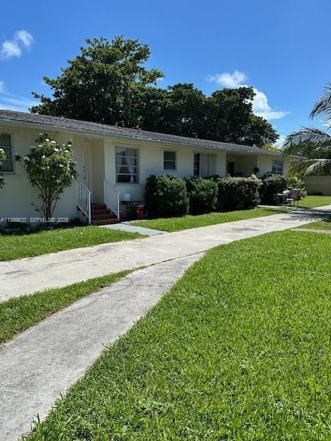 A single-story residential building with a concrete walkway and green lawn under a blue sky — 474 NW 26th Ave, Miami FL 33125, MIAMI, FL