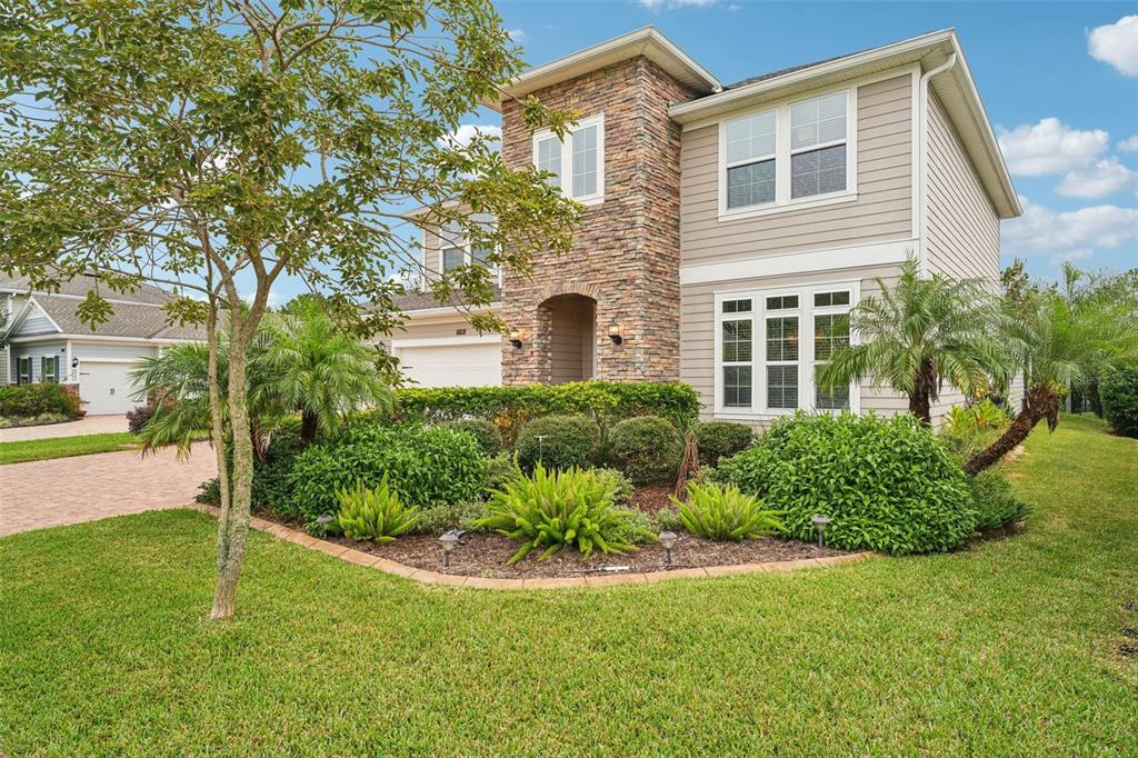 A two-story suburban house features a stone facade, beige siding, and a landscaped front yard — 2785 LAS CALINAS BOULEVARD, ST AUGUSTINE, FL
