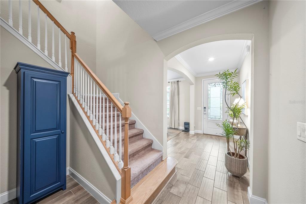 An entryway features a staircase with carpeted steps, a blue cabinet, and tile flooring — 2785 LAS CALINAS BOULEVARD, ST AUGUSTINE, FL