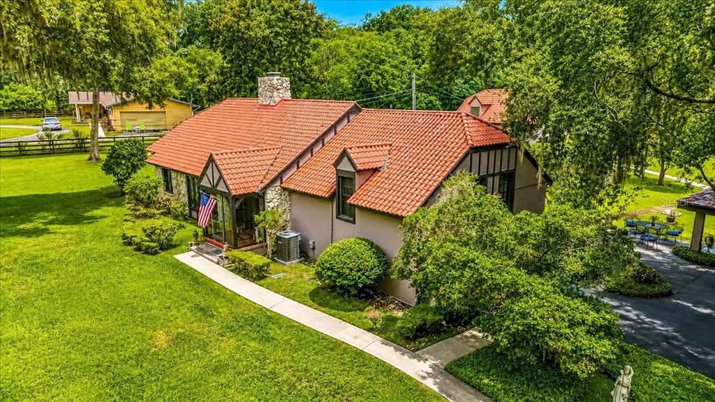 An aerial view shows a two-story guest house with a red tile roof and stairs — 411 SW 38TH STREET, OCALA, FL