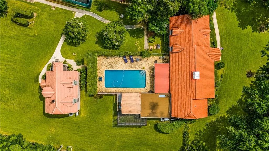 An aerial view shows a house with a red tile roof, pool, and detached structure — 411 SW 38TH STREET, OCALA, FL