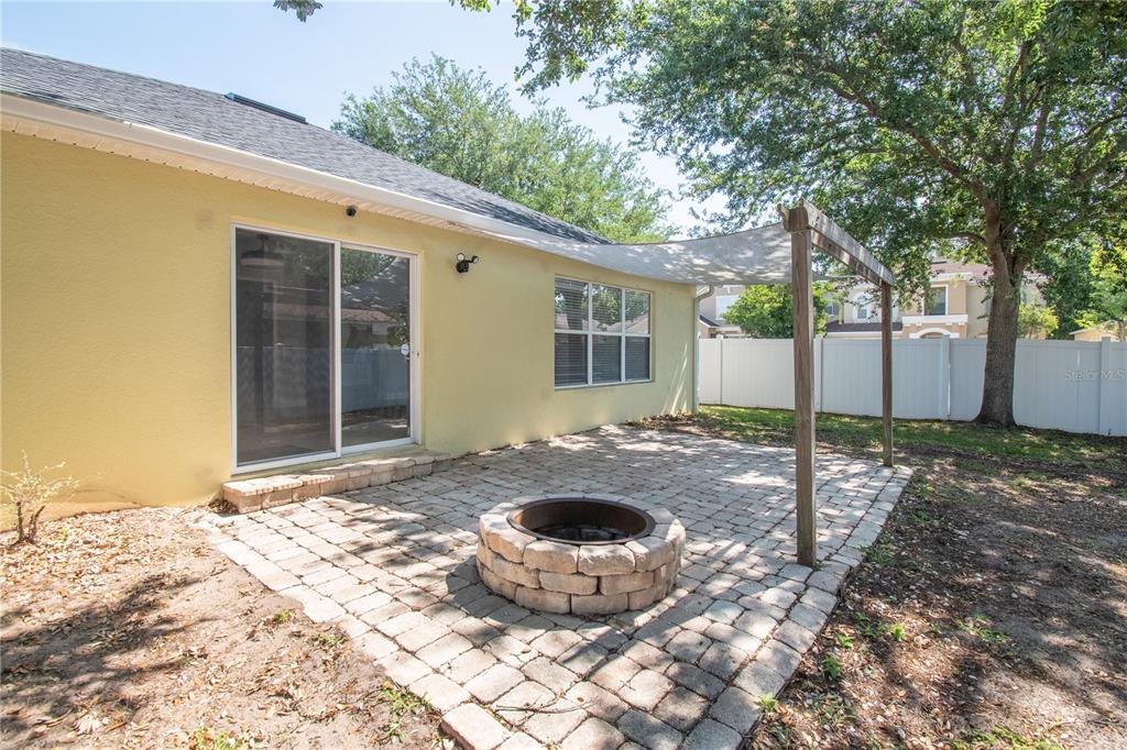 A living room with wood-look flooring, a fireplace, and an open kitchen with white cabinets — 5049 GANDROSS LANE, MOUNT DORA, FL