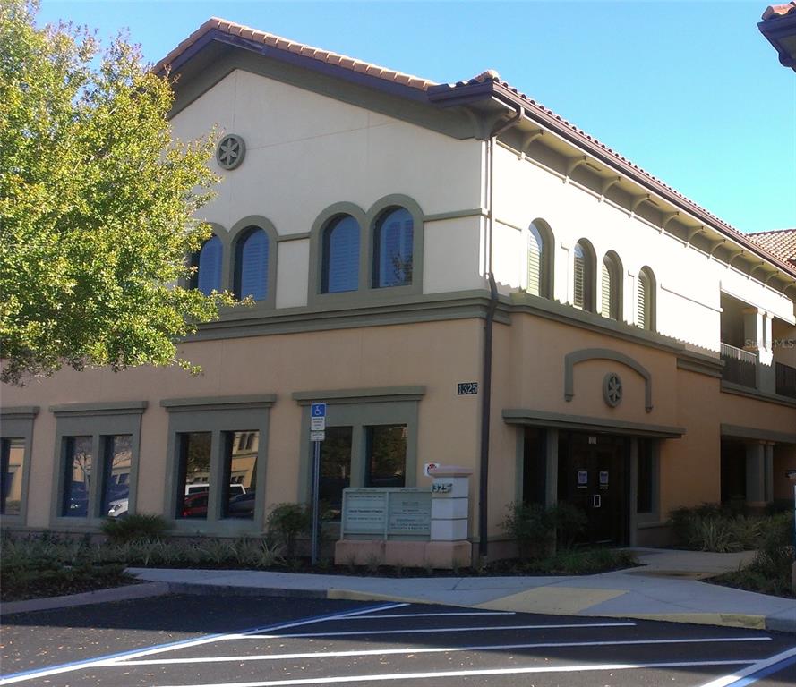 A two-story commercial building with a tan stucco exterior and arched windows — 1325 S INTERNATIONAL PKWY UNIT 2221, LAKE MARY, FL