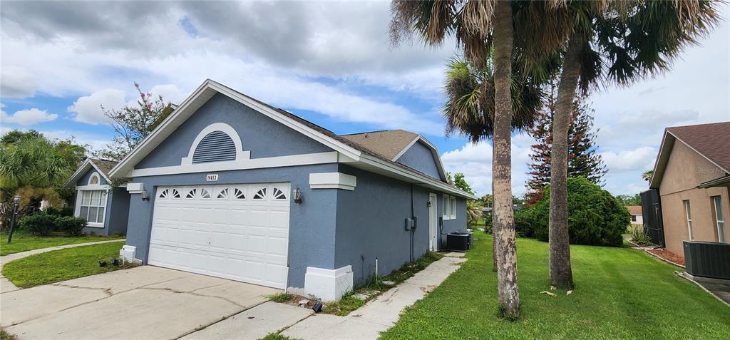 A blue house with a white garage door and palm trees in the front yard — 14613 LONE EAGLE DRIVE, ORLANDO, FL