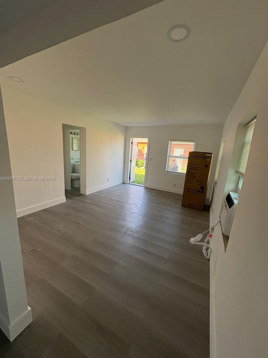 An interior view of a room with light wood-look flooring, white walls, and a doorway — 2316 Madison St # 6, Hollywood FL 33020, HOLLYWOOD, FL