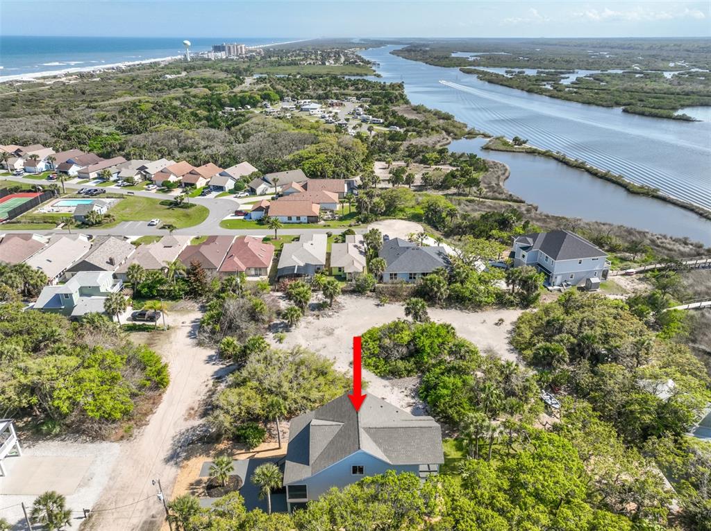 An aerial view shows a house with a gray roof surrounded by trees and water — 2738 JOHN BULL STREET, FLAGLER BEACH, FL