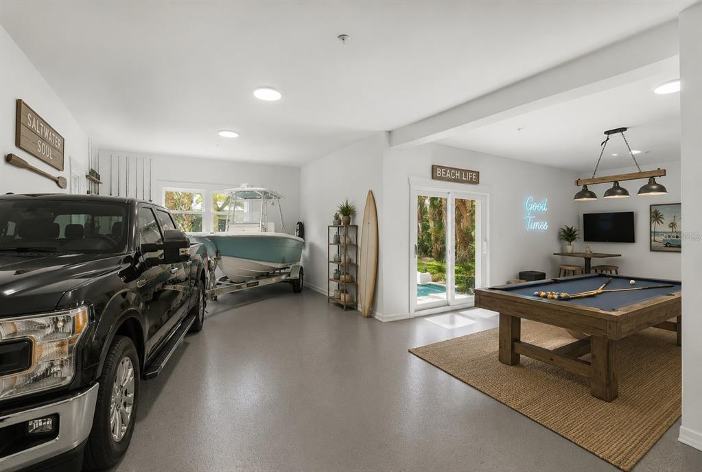 A garage converted into a game room with a pool table, boat, and parked truck — 2738 JOHN BULL STREET, FLAGLER BEACH, FL