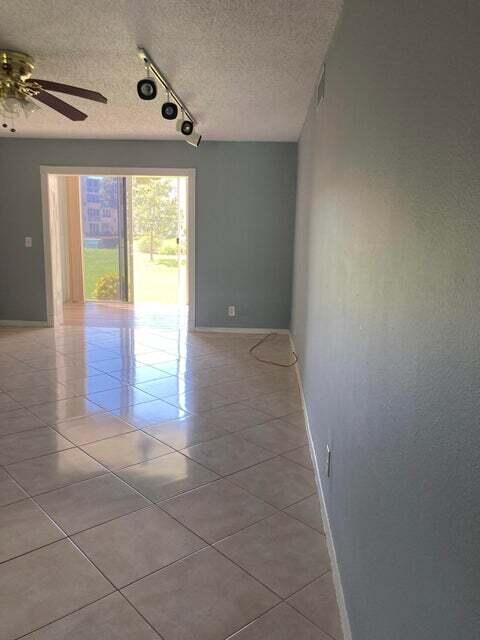 A room with light-colored tile flooring, a ceiling fan, track lighting, and a sliding glass door — 300 NE 26th Avenue NE # 1040, Boynton Beach FL 33435, BOYNTON BEACH, FL