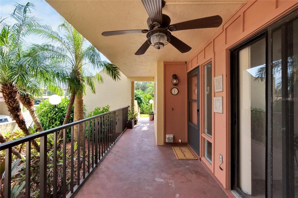 A covered outdoor balcony features a ceiling fan, metal railing, and a glass sliding door — 3415 WILD OAK BAY BOULEVARD UNIT 427, BRADENTON, FL