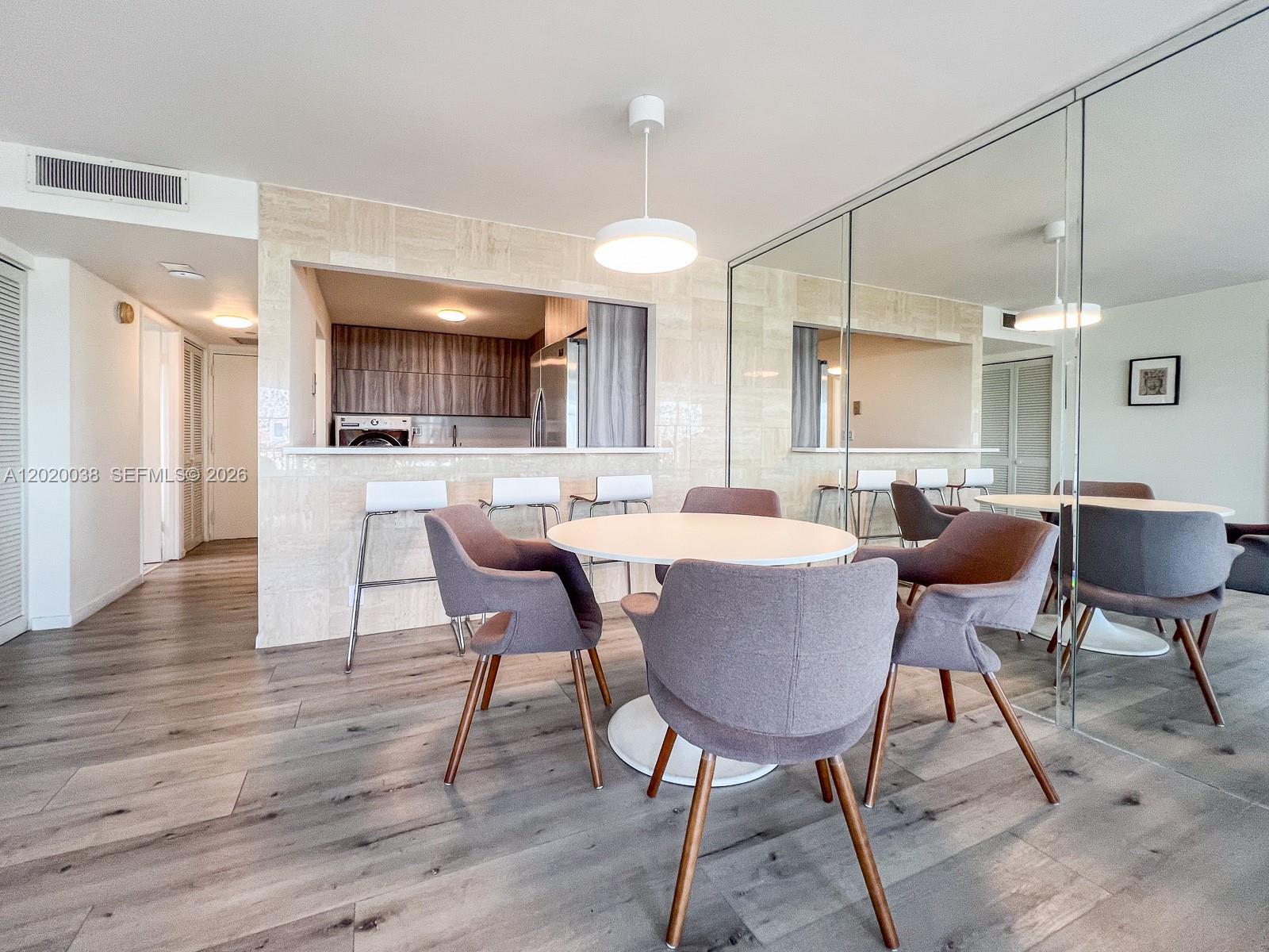 An interior room features light wood-look flooring, white walls with floating shelves, and a kitchen pass-through — 1901 Brickell Ave # B2004, Miami FL 33129, MIAMI, FL