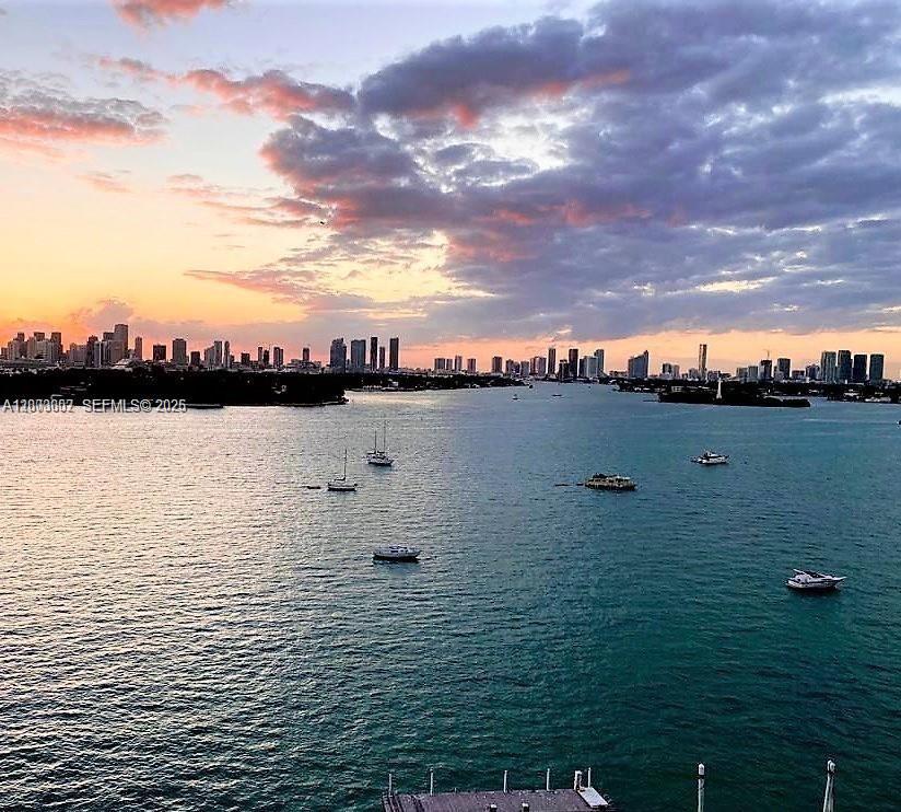 A view of a bay with boats at sunset against a city skyline — 1000 West Ave # 218, Miami Beach FL 33139, MIAMI BEACH, FL