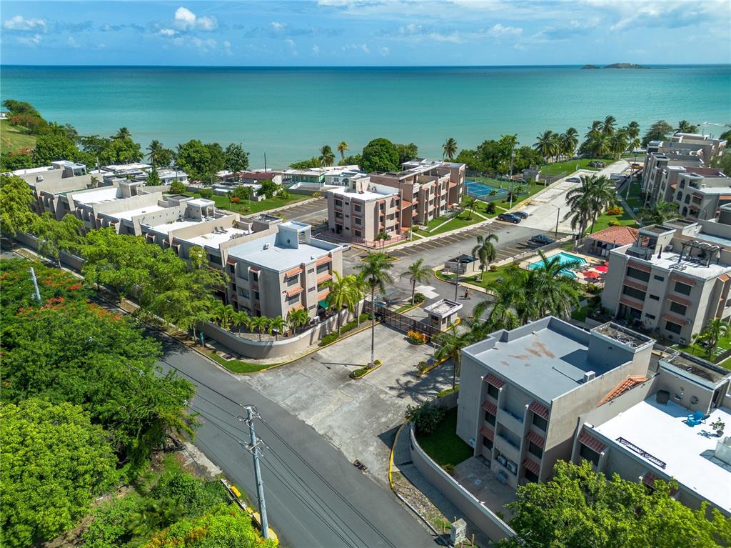 An aerial view shows a multi-building residential complex with a pool near the ocean — Cala de Hucares CARR 3 KM 66.7 UNIT B-208, NAGUABO, PR