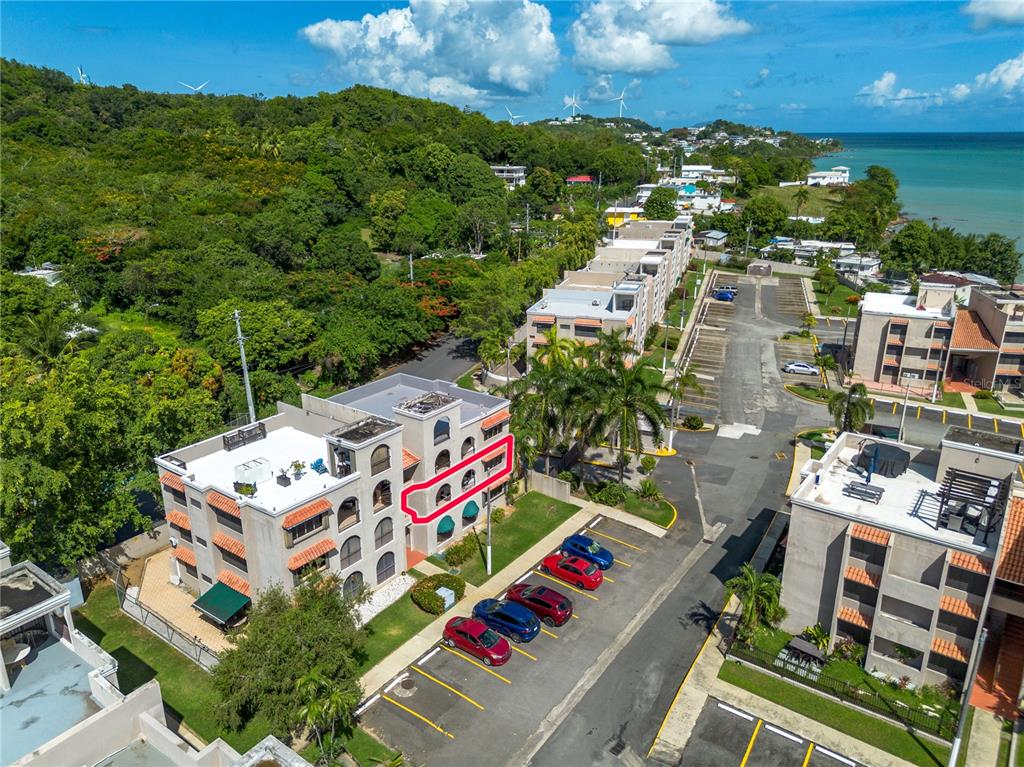 An aerial view shows a multi-story apartment building with a highlighted balcony and parking lot — Cala de Hucares CARR 3 KM 66.7 UNIT B-208, NAGUABO, PR