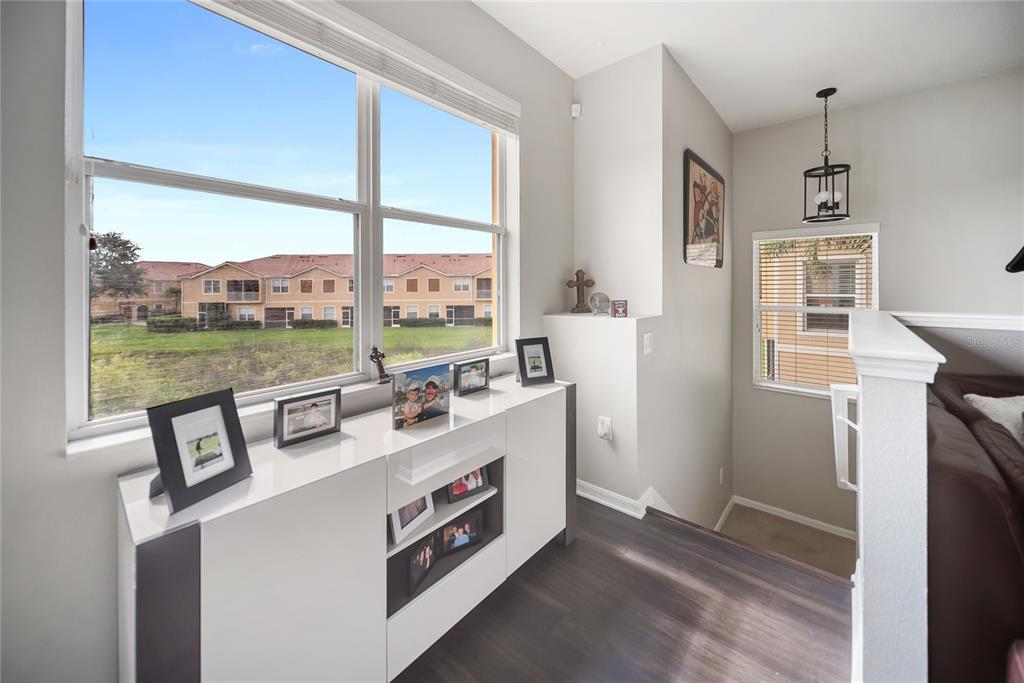A white console table sits beneath a large window overlooking a neighboring apartment complex — 3760 PARKRIDGE CIRCLE UNIT 23-204, SARASOTA, FL