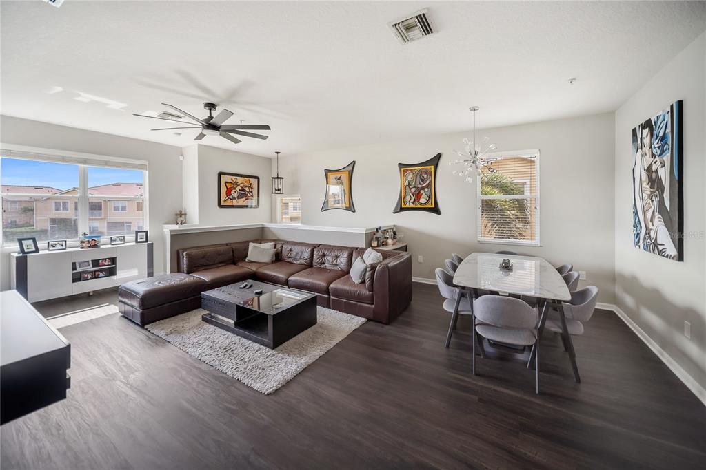A living and dining area features a brown sectional sofa, coffee table, and dining set — 3760 PARKRIDGE CIRCLE UNIT 23-204, SARASOTA, FL