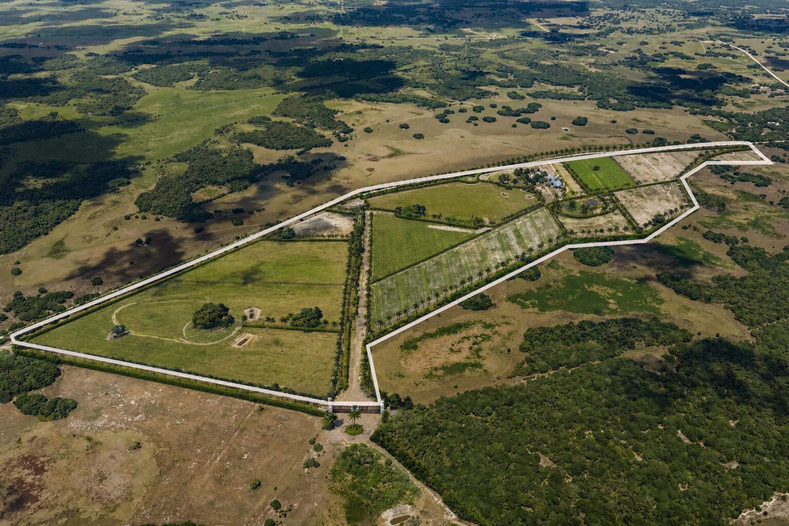 An aerial view shows a large, fenced rural property with green fields and palm-lined driveways — 0000 Hill Grade Road, Clewiston FL 33440, CLEWISTON, FL
