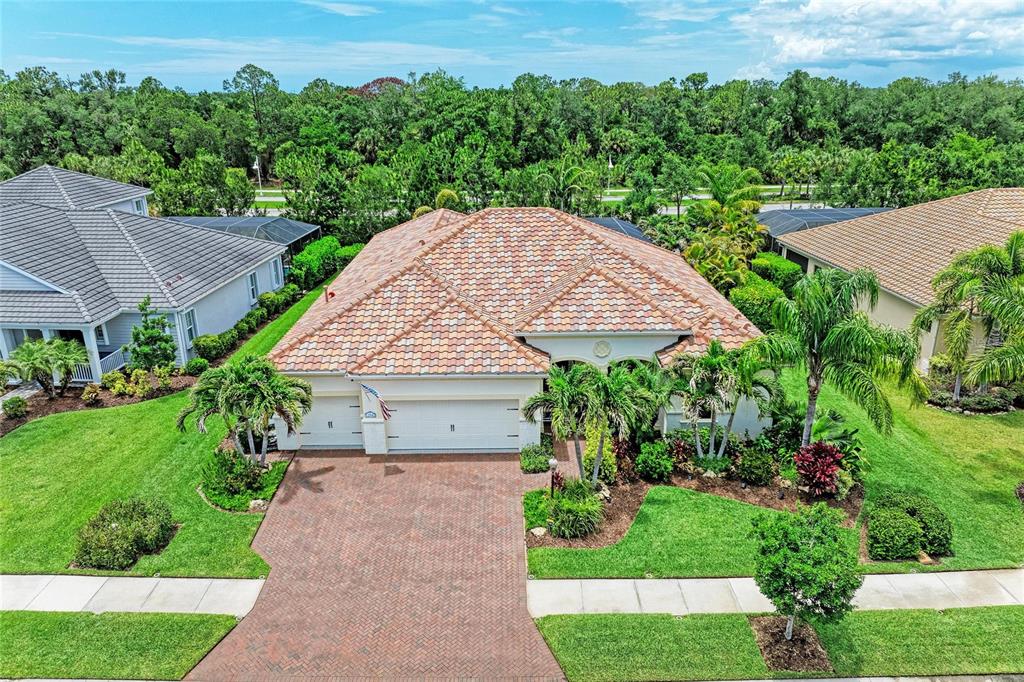 An aerial view of a single-story house with a tile roof and brick driveway — 12642 HARNEY STREET, VENICE, FL