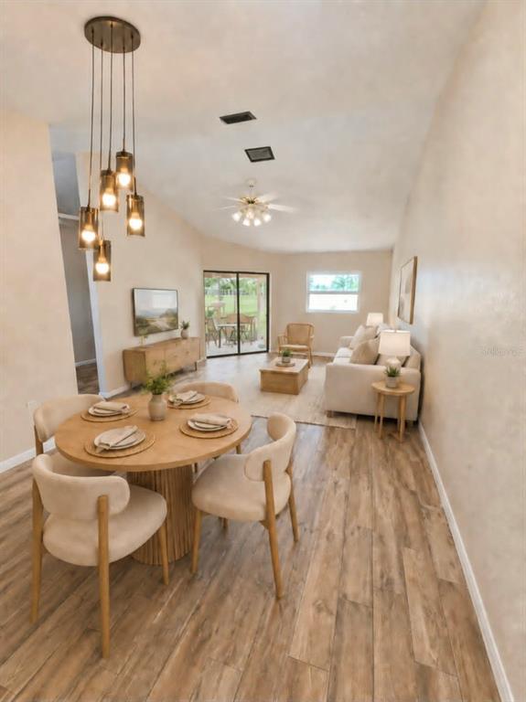A dining area with a round table and pendant lights opens into a living room — 1203 SAXONY CIRCLE UNIT A, PUNTA GORDA, FL