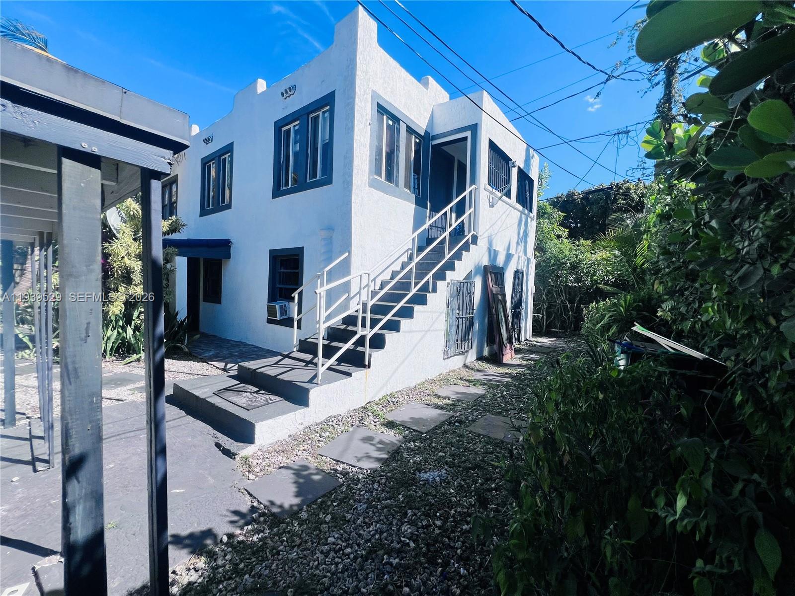 A two-story white stucco building features an exterior staircase leading to the upper level — 22 NE 51st St # 2, Miami FL 33137, MIAMI, FL