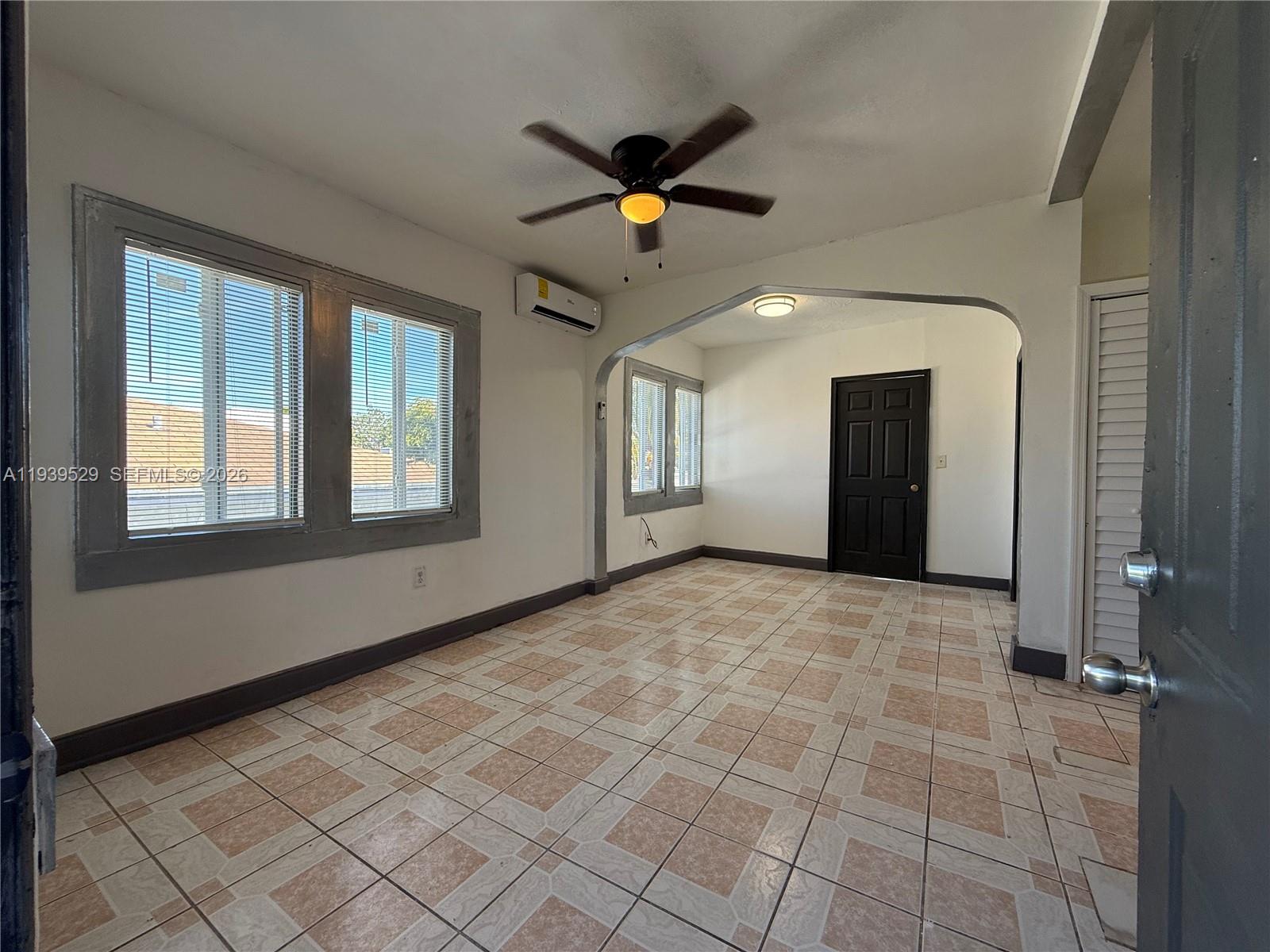 An interior room features tiled floors, an arched doorway, a ceiling fan, and window blinds — 22 NE 51st St # 2, Miami FL 33137, MIAMI, FL
