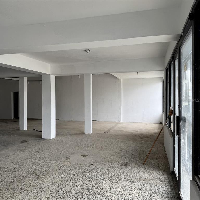 An empty commercial space features white support columns, white walls, and a speckled concrete floor — Calle 3 URB. FLAMBOYAN UNIT A-3, MANATI, PR