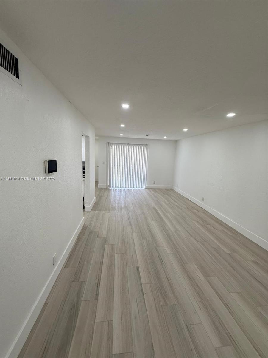 This empty room features light-colored wood-look flooring, white walls, and recessed ceiling lighting — 2655 NW 60th Way # 195, Sunrise FL 33313, SUNRISE, FL